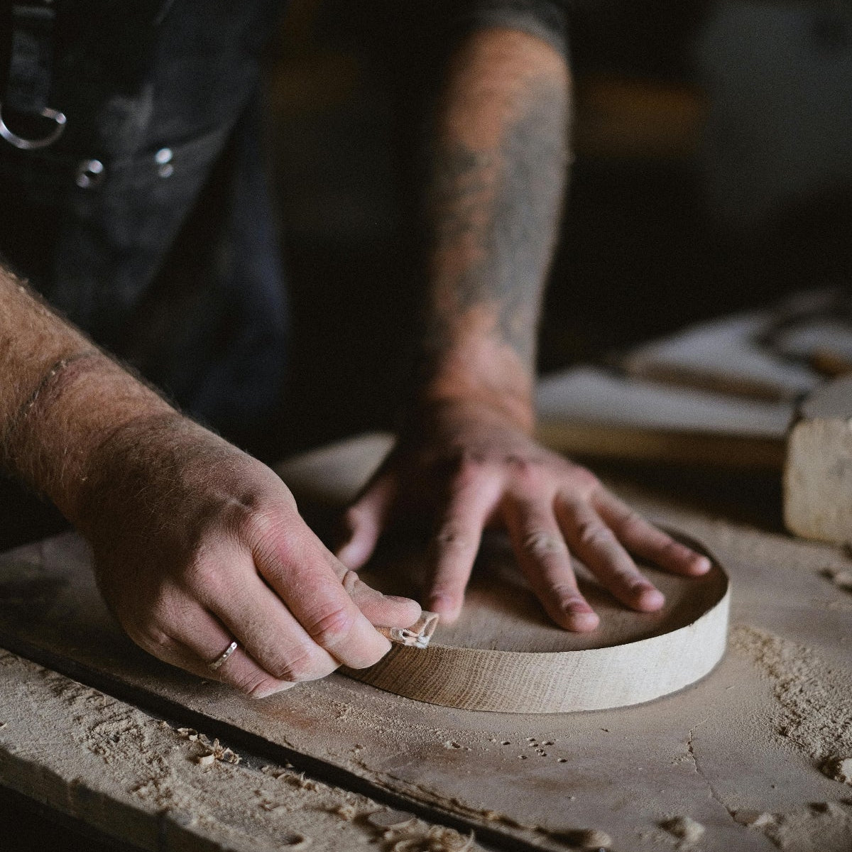 Person working with wood on a rustic workbench